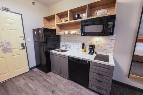 a small kitchen with a sink and a microwave at Candlewood Suites Merrillville by IHG in Merrillville