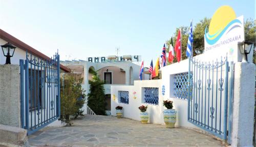 a row of white buildings with blue gates and flags at Chios Panorama in Karfas
