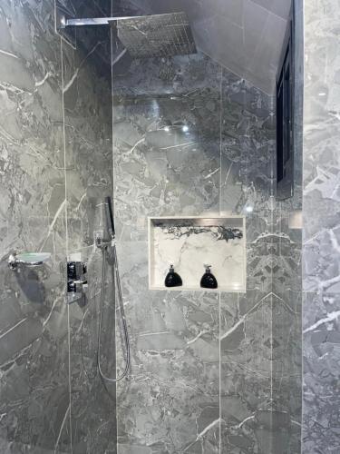 a bathroom with a shower with a glass door at Suna' a Home Bonapriso in Douala