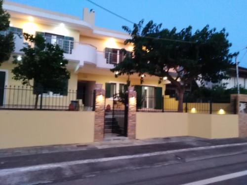 a white house with a fence in front of a street at SAN FLORAN in Áyios Flóros