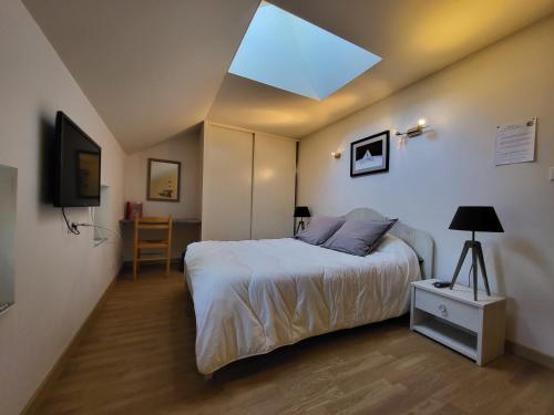 a bedroom with a bed and a skylight at Le Logis des Chons à la campagne à Saint hilaire du Bois - Lys Haut Layon in Le Plessis