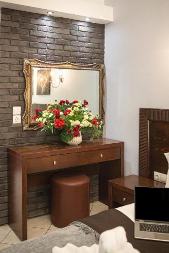 a room with a mirror and a table with flowers at Hotel Pithari in Agia Triada