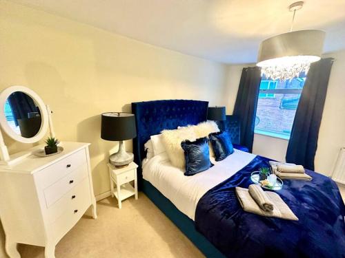 a bedroom with a blue bed and a window at Cottage,Cinema Room,Log Burner in Blaenavon