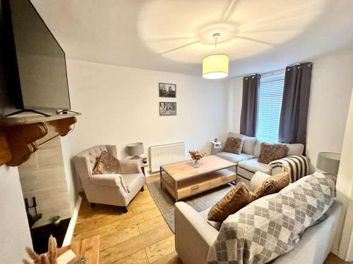 a living room with a couch and a tv at Cottage,Cinema Room,Log Burner in Blaenavon