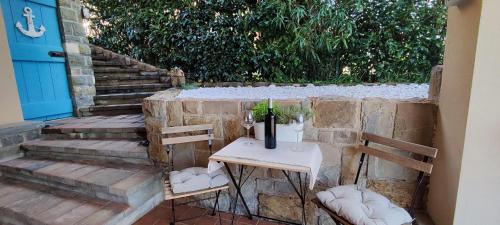 a table with two chairs and a bottle of wine on it at Olea Mar apartma in Pobegi