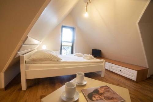 a small bedroom with a bed and a table at Willa Nad Wodospadem in Szczawnica
