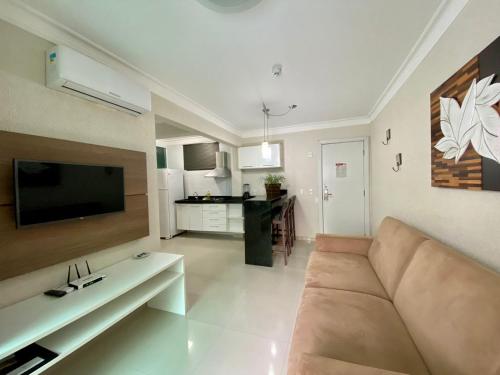 uma sala de estar com um sofá e uma cozinha em Bombinhas Summer Beach 252 em Bombas