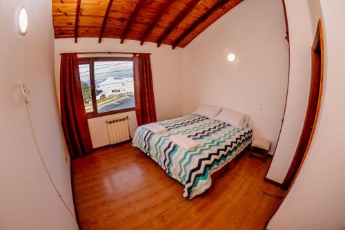 ein kleines Schlafzimmer mit einem Bett und einem Fenster in der Unterkunft Cabaña 1 Comoda, Cálida y Confortable in Ushuaia