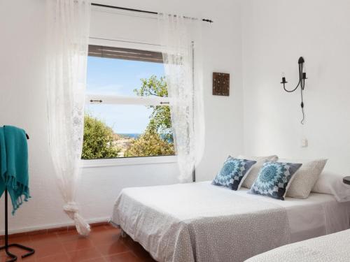 a white bedroom with two beds and a window at BEAUTIFUL HOUSE in TOSSA in Tossa de Mar