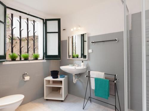 a bathroom with a sink and a toilet and windows at BEAUTIFUL HOUSE in TOSSA in Tossa de Mar