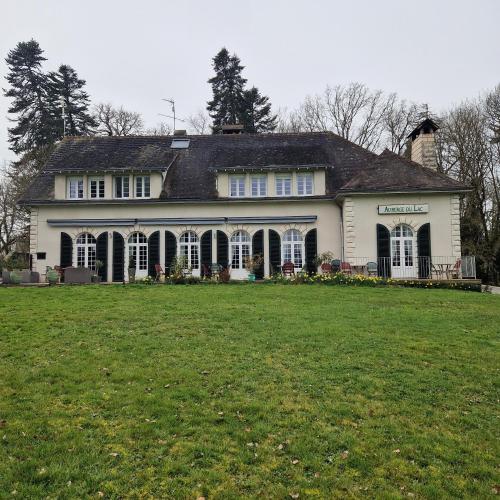 une grande maison blanche avec une grande cour dans l'établissement Aux Berges du Lac de Mondon, à Mailhac-sur-Benaize