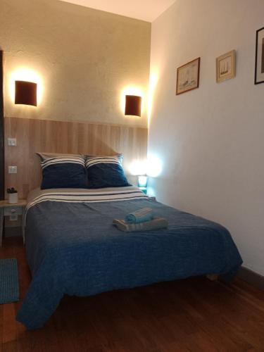 een slaapkamer met een groot bed en 2 handdoeken bij Aux Berges du Lac de Mondon in Mailhac-sur-Benaize