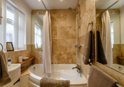 ein großes Bad mit einer Badewanne und einem Waschbecken in der Unterkunft The Beach Hut in Lowestoft