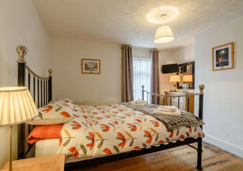 a bedroom with a bed with an orange and white comforter at The Beach Hut in Lowestoft