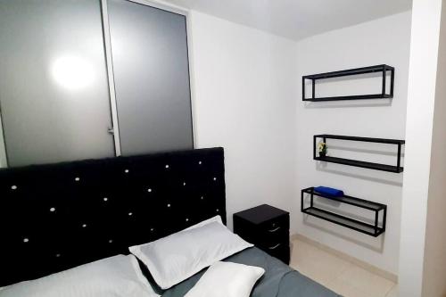 a bedroom with a bed with a black headboard at Apartamento completó 21 Cúcuta in Cúcuta