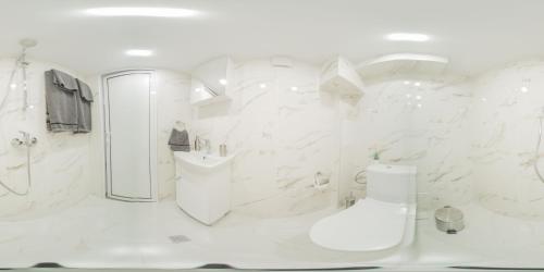 a white bathroom with a shower and a sink at Колеви хаус in Gabrovo