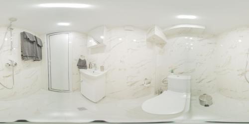 a white bathroom with a shower and a sink at Къща за гости - Kolevi House in Gabrovo