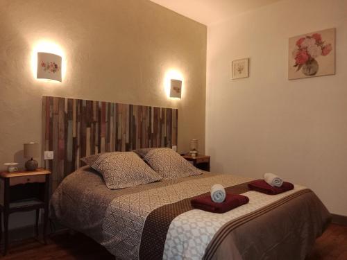 een slaapkamer met een bed met twee handdoeken erop bij Aux Berges du Lac de Mondon in Mailhac-sur-Benaize