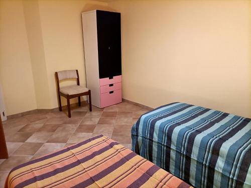 a bedroom with two beds and a chair and a dresser at Villa Twetty in Massaciuccoli
