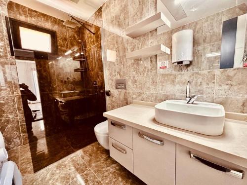 La salle de bains est pourvue d'un lavabo, de toilettes et d'une douche. dans l'établissement magnifique villa avec piscine prive kusadasi, à Kusadası
