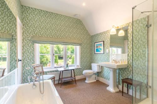 a bathroom with a tub and a sink and a toilet at The Five Arrows Hotel in Waddesdon
