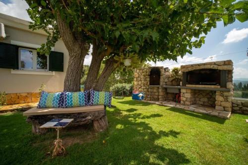 a couch sitting under a tree in a yard at Irini's country house in Gouvia
