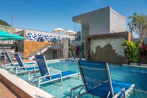 um grupo de cadeiras sentadas numa piscina em Royal Regency Palace Hotel no Rio de Janeiro