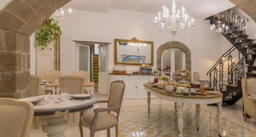 uma cozinha com duas mesas e cadeiras e uma sala de jantar em PALAZZO ALESSANDRINI GUEST HOUSE em Viterbo