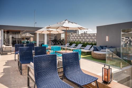 a patio with blue chairs and tables and umbrellas at Royal Regency Palace Hotel in Rio de Janeiro