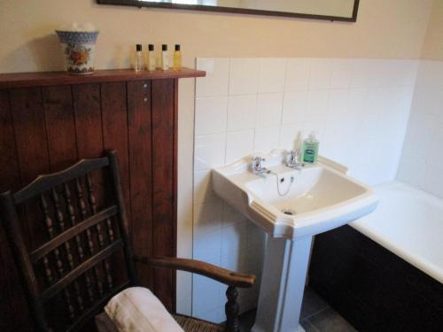 a bathroom with a sink and a bath tub at Blue Cabin Bridge Stores in Fritton