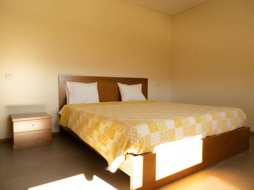 a bedroom with a bed and a night stand at Casa Malagueira in Fafião