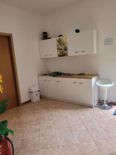 uma cozinha com armários brancos e piso em azulejo em Casa Patryk em Orşova