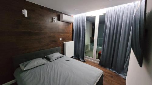 sypialnia z łóżkiem i dużym oknem w obiekcie Apartament AGA Mogilska Tower w Krakowie