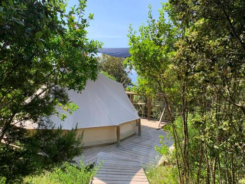 une grande tente blanche au milieu des arbres dans l'établissement Corsica Natura #2, à Coti-Chiavari