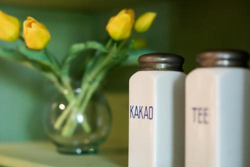 two white bottles sitting next to a vase with flowers at Bodensee Apartments, Sauna, Lake Walks, Free Parking, Self Checkin, Nature Reserve, Restaurants Nearby in Gaißau