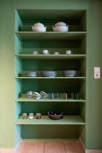 a shelf filled with dishes and bowls in a kitchen at Bodensee Apartments, Sauna, Lake Walks, Free Parking, Self Checkin, Nature Reserve, Restaurants Nearby in Gaißau