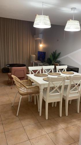 une salle à manger avec des tables et des chaises blanches dans l'établissement Ponta Grande Villa 29, à Albufeira