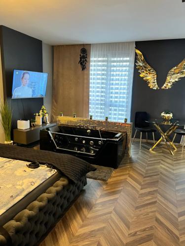 1 dormitorio con bañera grande y TV en Apartament Pod Skrzydłami Aniola, en Bytom
