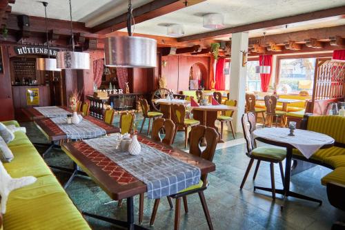 restauracja ze stołami i krzesłami w pokoju w obiekcie Hotel Almrausch w mieście Reit im Winkl