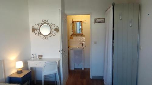 een badkamer met een wastafel en een spiegel aan de muur bij Les Bois Flottés en Ré in Sainte-Marie-de-Ré