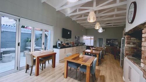 a kitchen and dining room with tables and chairs at Aha! Cheers Guesthouse 拾间-海 in Walvis Bay