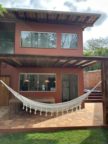 a house with a hammock in front of it at Lençóis em cantos in Lençóis
