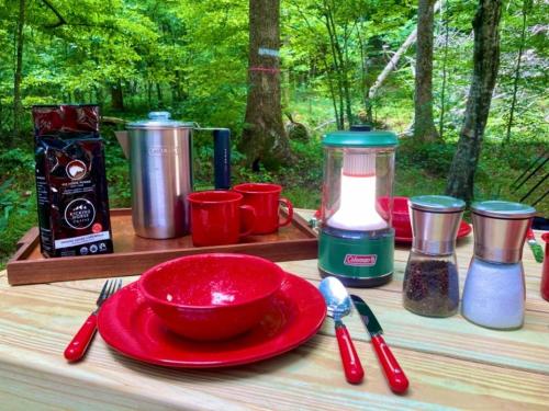uma mesa com um prato vermelho e utensílios nela em Tentrr Signature Site - Wander em Scottsville