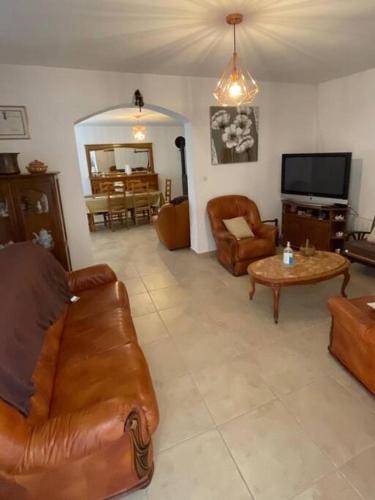 un salon avec un canapé, des chaises et une télévision dans l'établissement villa gambotti, à Morta