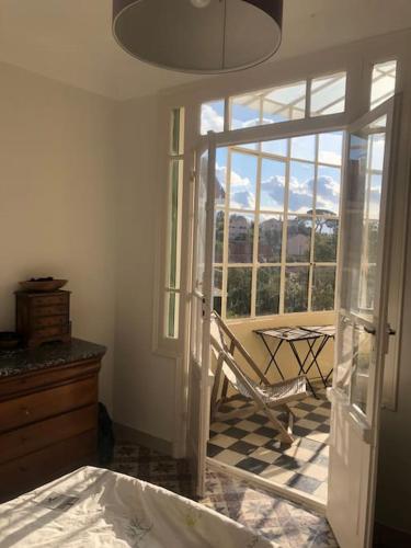 a bedroom with a sliding glass door with a chair at Villa - Toulon/La Mitre - plages à pied - 9 couchages in Toulon