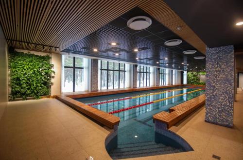 a swimming pool in a building with benches and a swimming pool at Seaside apartment Albatross, 16 in Ķesterciems