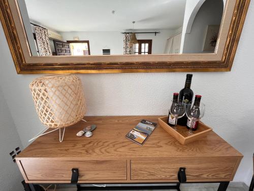 een tafel met twee flessen wijn en een spiegel bij Casa del Pescador en Vera in Vera