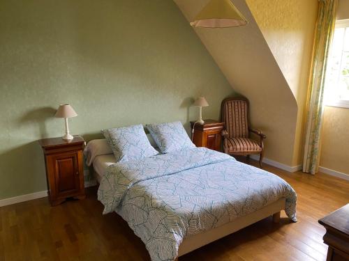 - une chambre avec un lit, deux tables et une chaise dans l'établissement Maison tout confort proche des plages, à Ploemeur