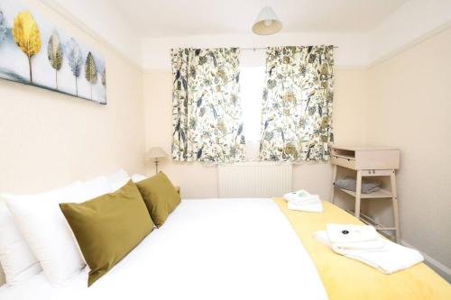 ein Schlafzimmer mit einem weißen Bett und einem Fenster in der Unterkunft Wolsey Road, North Oxford in Oxford