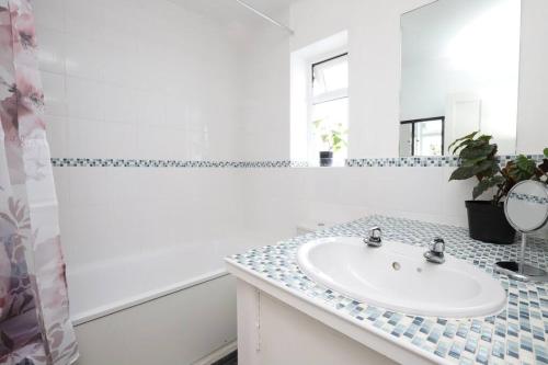 een witte badkamer met een wastafel en een spiegel bij Wolsey Road, North Oxford in Oxford